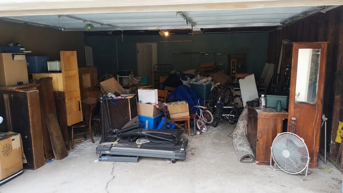 Cluttered two-car garage in Evansville before a professional cleanout